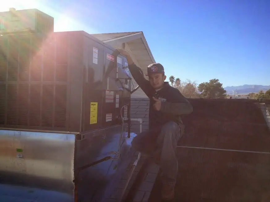 HVAC technician performing Heat Pump Repair on a rooftop unit in West Jordan